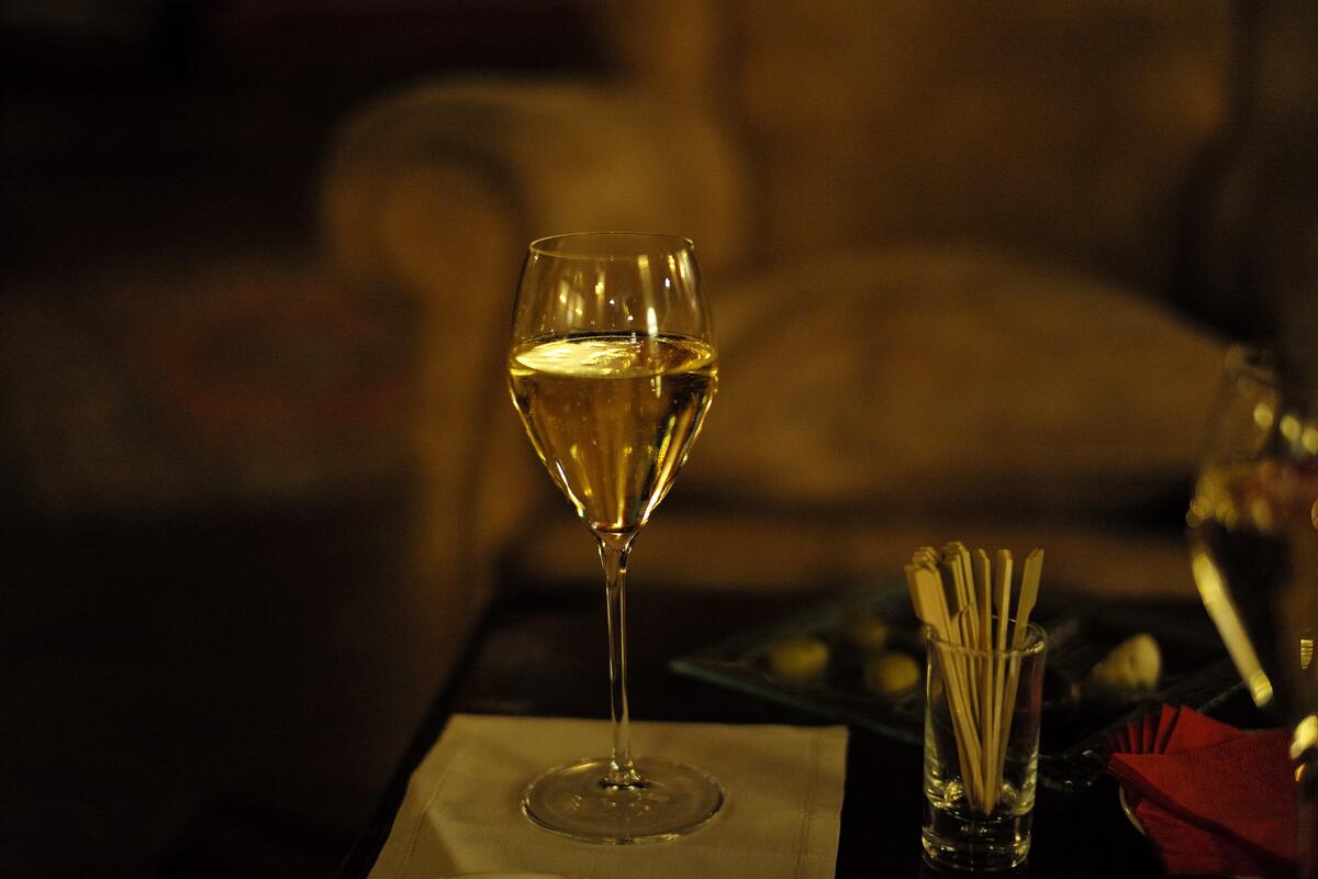 A glass of wine on a candlelit table
